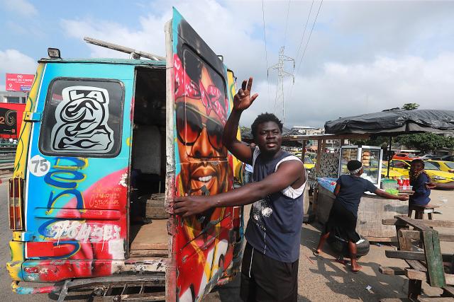 (260722) -- ABIDJAN, July 22, 2026 (Xinhua) -- A minibus conductor calls for passengers in Abidjan, Cote d'Ivoire, on July 21, 2026. Colorful minibuses serve as a primary mode of transport and a vibrant element of local street culture in Abidjan, the economic capital of Cote d'Ivoire. (Photo by Yvan Sonh/Xinhua)