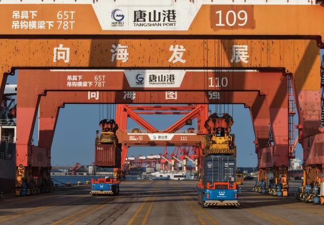(260722) -- TANGSHAN, July 22, 2026 (Xinhua) -- A drone photo taken on July 21, 2026 shows unmanned vehicles transporting containers at the Jingtang area of Tangshan Port in Tangshan, north China's Hebei Province. Cargo throughput of Tangshan Port reached 445.56 million tonnes in the first half of 2026, up 2.77 percent year on year, according to local port administration. (Xinhua/Yang Shiyao)