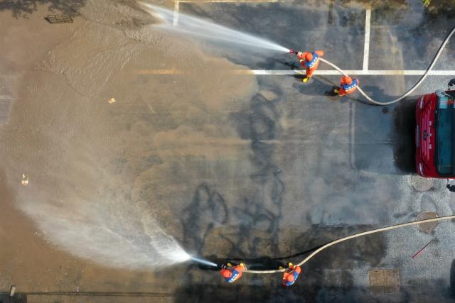(260722) -- DUNHUA, July 22, 2026 (Xinhua) -- An aerial drone photo taken on July 21, 2026 shows firefighters clearing sludge at a residential compound in Dunhua, Yanbian Korean Autonomous Prefecture, northeast China's Jilin Province. Flood recovery efforts were underway after the city was hit by flooding caused by a typhoon. (Xinhua/Zhang Nan)