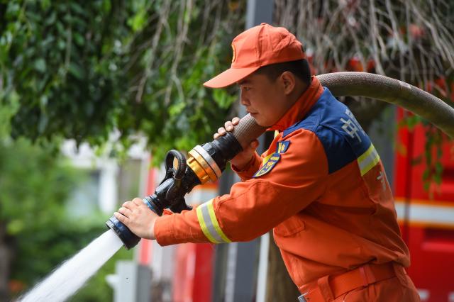 (260722) -- DUNHUA, July 22, 2026 (Xinhua) -- A firefighter clears sludge at a residential compound in Dunhua, Yanbian Korean Autonomous Prefecture, northeast China's Jilin Province, July 21, 2026. Flood recovery efforts were underway after the city was hit by flooding caused by a typhoon. (Xinhua/Zhang Nan)