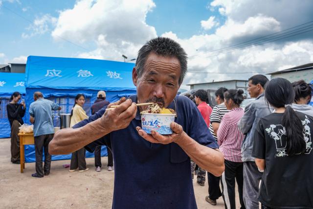 (260722) -- MOJIANG, July 22, 2026 (Xinhua) -- A villager has a meal at a temporary shelter at Jingping Village in Yutang Town of Mojiang Hani Autonomous County, southwest China's Yunnan Province, on July 22, 2026. The Yunnan provincial earthquake relief headquarters has activated a Level-IV emergency response after a 5.0-magnitude earthquake jolted Mojiang on Tuesday, local authorities said.
   No casualties have been reported so far. (Xinhua/Chen Xinbo)