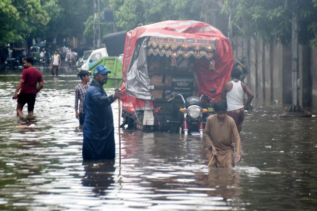 (260722) -- LAHORE, July 22, 2026 (Xinhua) -- People wade through a flooded street after heavy monsoon rains in Lahore, Pakistan, July 22, 2026.
  At least eight people were killed and 16 others injured in rain-related incidents across Pakistan over the past 24 hours as monsoon showers continued to batter parts of the country, the National Disaster Management Authority said on Tuesday. (Photo by Sajjad/Xinhua)