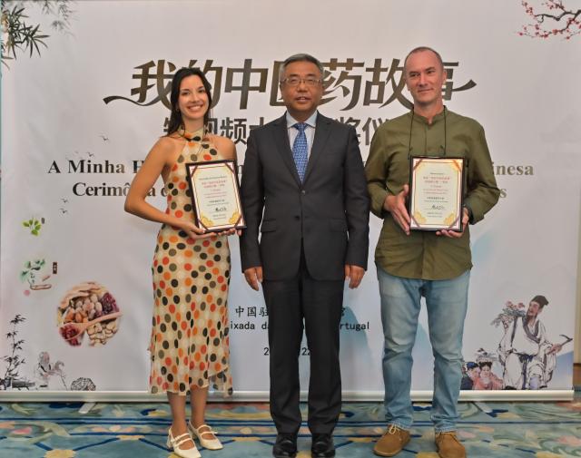(260722) -- LISBON, July 22, 2026 (Xinhua) -- Chinese Ambassador to Portugal Yang Yirui presents the first prize to winners of the "My Story with Traditional Chinese Medicine" short video contest in Lisbon, Portugal, July 22, 2026. TO GO WITH "Traditional Chinese medicine wins wider recognition in Portugal" (Xinhua/Xun Wei)