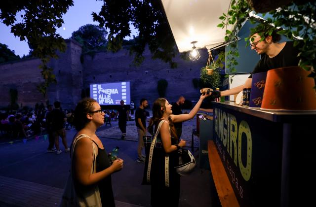 (260723) -- ROME, July 23, 2026 (Xinhua) -- People buy food before watching a film during the summer edition of the Cinema Alle Mura festival in front of the ancient Aurelian Walls Park in Rome, Italy, July 22, 2026. (Xinhua/Wang Kaiyan)