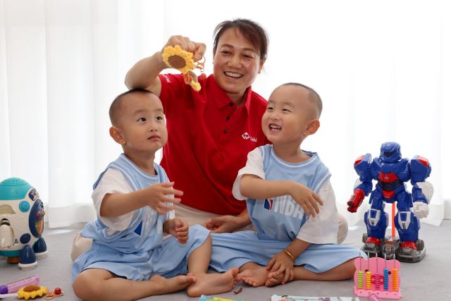 (260723) -- JINAN, July 23, 2026 (Xinhua) -- A babysitter takes care of twins at a household in Zaozhuang City, east China's Shandong Province, July 21, 2026. A number of domestic services brands have emerged in Shandong in recent years, offering widely ranging services such as eldercare, maternity care, and in-home caregiving. (Photo by Sun Zhongzhe/Xinhua)