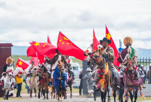 (260723) -- AMDO, July 23, 2026 (Xinhua) -- Riders enter the venue of a horse racing competition in Amdo County, southwest China's Xizang Autonomous Region, July 23, 2026. The horse racing competition kicked off here on Thursday, featuring vibrant performances and horse racing events. (Xinhua/Tenzin Nyida)