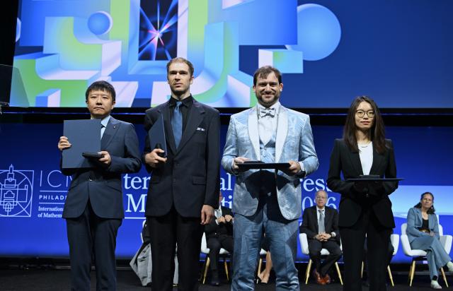 (260723) -- PHILADEPHIA, July 23, 2026 (Xinhua) -- Fields Medalists Deng Yu (1st L) and Wang Hong (1st R), both Chinese mathematicians, John Pardon (2nd L), an American mathematician, and Jacob Tsimerman, a Canadian mathematician, pose for a group photograph at the opening ceremony of the 2026 International Congress of Mathematicians in Philadelphia, the United States, July 23, 2026. Chinese mathematicians Deng Yu and Wang Hong were awarded the Fields Medals at the opening ceremony of the 2026 International Congress of Mathematicians held here on Thursday, marking the first time Chinese mathematicians have won the prestigious honor. The other recipients of the 2026 Fields Medals are American John Pardon and Canada's Jacob Tsimerman. (Xinhua/Li Rui)