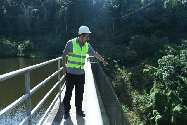 (260723) -- MARSABIT, July 23, 2026 (Xinhua) -- Zhang Yang, deputy project manager of the water project, inspects the newly built Bakuli No.4 Dam, a modern water supply facility constructed by Power Construction Corporation of China, in Marsabit National Park, Kenya, July 14, 2026. TO GO WITH "Feature: Chinese-built water project transforms life in Kenya's arid town" (Xinhua/Liu Qiong)