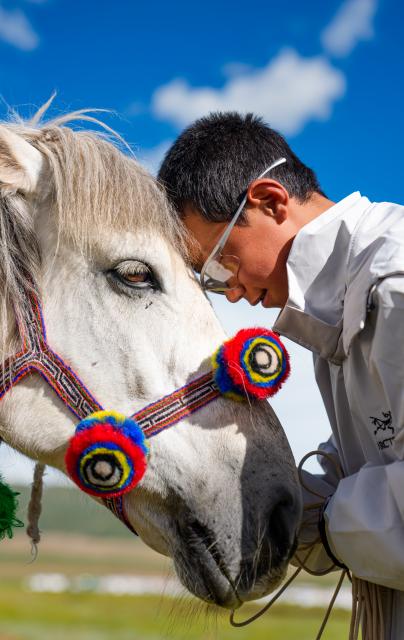 (260724) -- BEIJING, July 24, 2026 (Xinhua) -- A young rider is pictured with his horse ahead of a horse racing competition in Amdo County, southwest China's Xizang Autonomous Region, July 22, 2026. The horse racing competition kicked off here on Thursday, featuring vibrant performances and horse racing events. (Xinhua/Tenzin Nyida)