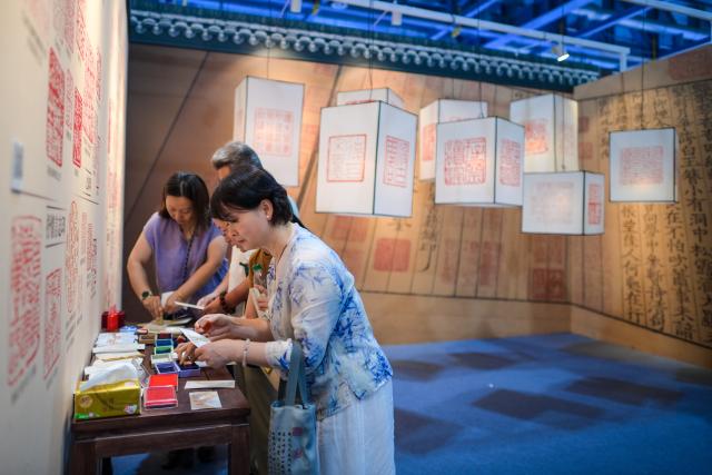 (260724) -- HANGZHOU, July 24, 2026 (Xinhua) -- People visit the 34th National Book Expo in Hangzhou, east China's Zhejiang Province, July 24, 2026. The event kicked off here on Friday with nearly a million publications of various types on display, either online or on site. (Xinhua/Jiang Han)