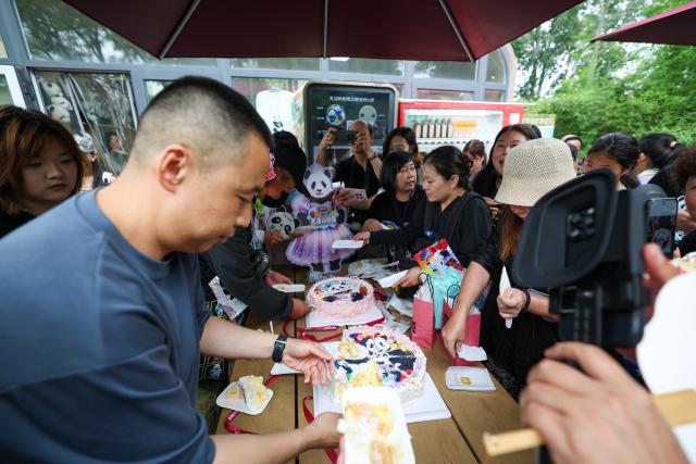 (260724) -- TIANJIN, July 24, 2026 (Xinhua) -- People share cakes in celebration of giant panda Xi Le's birthday at Tianjin Zoo in north China's Tianjin, on July 24, 2026. The Tianjin Zoo celebrated Xi Le's 13th birthday on Friday. Xi Le was born in 2013 in Ya'an City, southwest China's Sichuan Province, and transferred to the Tianjin Zoo in 2015. (Xinhua/Sun Fanyue)