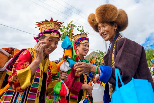 (260724) -- SHANNAN, July 24, 2026 (Xinhua) -- An elder dressed in traditional attire offers highland barley wine to people before celebrating the Ongkor Festival at Tashi Chodan Community in Shannan, southwest China's Xizang Autonomous Region, July 24, 2026. The Tashi Chodan Community in Shannan celebrated the annual Ongkor Festival, a national intangible cultural heritage, on Friday. Local people paraded around the farmland to pray for a bumper harvest during the festival, whose specific date varies according to the ripening time of crops in different regions. (Xinhua/Tenzin Nyida)