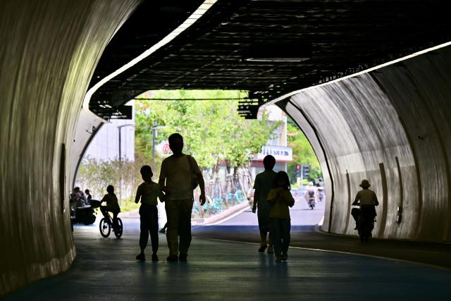 (260724) -- FUZHOU, July 24, 2026 (Xinhua) -- Residents relax in a tunnel to cool off in Fuzhou, southeast China's Fujian Province, July 18, 2026. As summer temperatures soar, Fuzhou has made some tunnels, air-raid shelters and metro stations available as public cooling spaces. Equipped with benches, chairs and other convenience facilities, these sites have become popular for residents to relax and escape the heat. (Xinhua/Jiang Kehong)