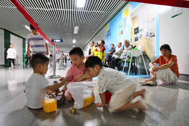 (260724) -- FUZHOU, July 24, 2026 (Xinhua) -- Residents enjoy leisure time at a rest area of a metro station to cool off in Fuzhou, southeast China's Fujian Province, July 24, 2026. As summer temperatures soar, Fuzhou has made some tunnels, air-raid shelters and metro stations available as public cooling spaces. Equipped with benches, chairs and other convenience facilities, these sites have become popular for residents to relax and escape the heat. (Xinhua/Jiang Kehong)