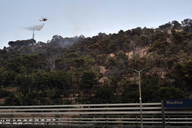 (260724) -- ROME, July 24, 2026 (Xinhua) -- This photo taken on July 18, 2026 shows firefighters fighting a fire with a helicopter at Modica of Sicily, Italy. A new round of extreme heat is tightening its grip on Europe from the Mediterranean to Scandinavia, setting local temperature records and fueling wildfires, violent storms and growing safety risks. Weeks of scorching temperatures and scarce rainfall have also pushed major rivers to historic lows, disrupting shipping, industry and agriculture, while forecasters warn another heat surge could arrive around the turn of the month. 
   TO GO WITH "Roundup: Extreme heat tests Europe as fires spread and rivers run low" (Photo by Edgardo Cerruto/Xinhua)