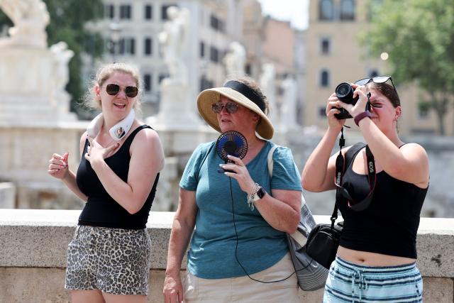 (260724) -- ROME, July 24, 2026 (Xinhua) -- A tourist uses a portable fan to cool off while visiting the Ponte Sant'Angelo during a heatwave in Rome, Italy, July 19, 2026. A new round of extreme heat is tightening its grip on Europe from the Mediterranean to Scandinavia, setting local temperature records and fueling wildfires, violent storms and growing safety risks. Weeks of scorching temperatures and scarce rainfall have also pushed major rivers to historic lows, disrupting shipping, industry and agriculture, while forecasters warn another heat surge could arrive around the turn of the month. 
   TO GO WITH "Roundup: Extreme heat tests Europe as fires spread and rivers run low" (Xinhua/Li Jing)