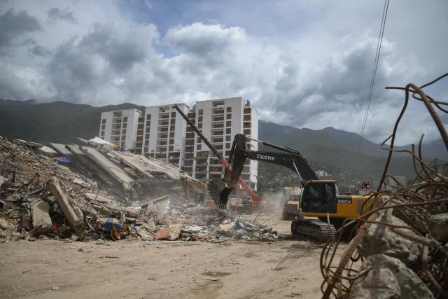 (260724) -- LA GUAIRA, July 24, 2026 (Xinhua) -- Rescuers work on a collapsed building in La Guaira State, Venezuela, July 23, 2026. The death toll from the June 24 earthquakes in Venezuela has risen to 5,398 as crews continue to clear rubble in the hardest-hit areas. (Photo by Marcos Salgado/Xinhua)