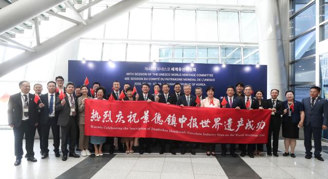 (260725) -- BUSAN, July 25, 2026 (Xinhua) -- Chinese delegates celebrate the inscription of China's Jingdezhen Handicraft Porcelain Industry Sites on the United Nations Educational, Scientific and Cultural Organization (UNESCO) World Heritage List outside the venue of the 48th session of the World Heritage Committee in Busan, South Korea, July 25, 2026. The UNESCO added China's Jingdezhen Handicraft Porcelain Industry Sites to the World Heritage List on Saturday during the 48th session of the World Heritage Committee held in Busan, South Korea.
   The inscription brings the total number of World Heritage sites in China to 61. (Xinhua/Yao Qilin)