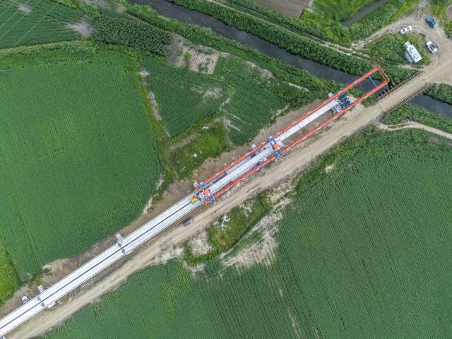 (260725) -- JIAMUSI, July 25, 2026 (Xinhua) -- An aerial drone photo taken on July 23, 2026 shows the construction site of the Tongjiang super major bridge in northeast China's Heilongjiang Province. The beam erection work of the 10,435-meter Tongjiang super major bridge, which is part of the capacity expansion and upgrading project for the Jiamusi-Tongjiang Railway, was successfully completed on Saturday. 
   Upon completion, the 258-kilometer-long railway will boost the transport capacity of Tongjiang port, a key gateway along the eastern route of the China-Europe freight train service. (Xinhua/Wang Song)