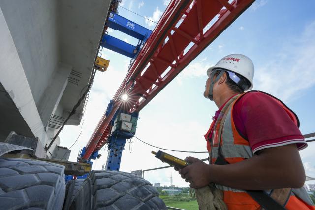 (260725) -- JIAMUSI, July 25, 2026 (Xinhua) -- A staff member works at the construction site of the Tongjiang super major bridge in northeast China's Heilongjiang Province, July 23, 2026. The beam erection work of the 10,435-meter Tongjiang super major bridge, which is part of the capacity expansion and upgrading project for the Jiamusi-Tongjiang Railway, was successfully completed on Saturday. 
   Upon completion, the 258-kilometer-long railway will boost the transport capacity of Tongjiang port, a key gateway along the eastern route of the China-Europe freight train service. (Xinhua/Wang Song)