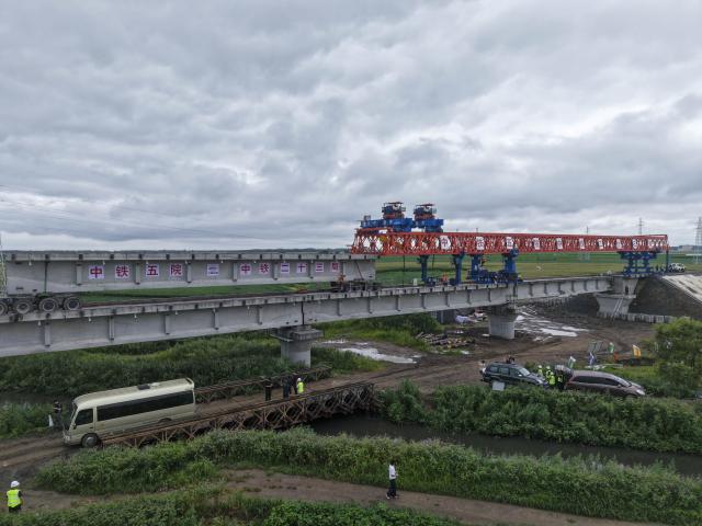 (260725) -- JIAMUSI, July 25, 2026 (Xinhua) -- An aerial drone photo taken on July 25, 2026 shows the construction site of the Tongjiang super major bridge in northeast China's Heilongjiang Province. The beam erection work of the 10,435-meter Tongjiang super major bridge, which is part of the capacity expansion and upgrading project for the Jiamusi-Tongjiang Railway, was successfully completed on Saturday. 
   Upon completion, the 258-kilometer-long railway will boost the transport capacity of Tongjiang port, a key gateway along the eastern route of the China-Europe freight train service. (Xinhua/Wang Song)