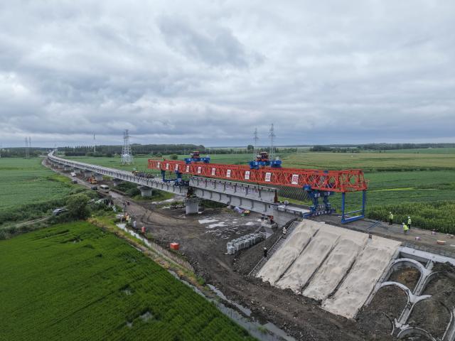 (260725) -- JIAMUSI, July 25, 2026 (Xinhua) -- An aerial drone photo taken on July 25, 2026 shows the construction site of the Tongjiang super major bridge in northeast China's Heilongjiang Province. The beam erection work of the 10,435-meter Tongjiang super major bridge, which is part of the capacity expansion and upgrading project for the Jiamusi-Tongjiang Railway, was successfully completed on Saturday. 
   Upon completion, the 258-kilometer-long railway will boost the transport capacity of Tongjiang port, a key gateway along the eastern route of the China-Europe freight train service. (Xinhua/Wang Song)