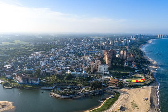 (260725) -- QIONGHAI, July 25, 2026 (Xinhua) -- An aerial drone photo taken on July 23, 2026 shows the scenery of Hainan's round-the-island highway and Boao Town in Qionghai City, south China's Hainan Province. Building on the unique identities of Boao Town, home to the Boao Forum for Asia, and Tanmen Town, a historic fishing port with a thousand-year legacy, Qionghai City has been advancing the coordinated construction of picturesque rural villages across the Boao-Tanmen area. Taking advantage of Hainan's round-the-island highway, the city has linked both newly constructed and previously cultivated beautiful and harmonious villages into a cohesive chain to forge a globally influential rural revitalization belt. (Xinhua/Pu Xiaoxu)