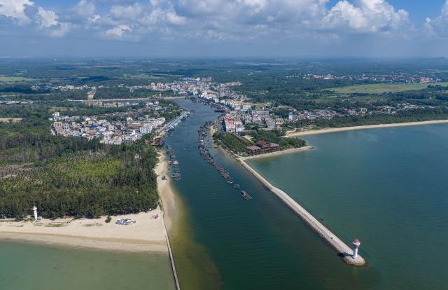 (260725) -- QIONGHAI, July 25, 2026 (Xinhua) -- An aerial drone photo taken on July 24, 2026 shows the Paigang Village and Tanmen fishing port in Tanmen Town, Qionghai City, south China's Hainan Province. Building on the unique identities of Boao Town, home to the Boao Forum for Asia, and Tanmen Town, a historic fishing port with a thousand-year legacy, Qionghai City has been advancing the coordinated construction of picturesque rural villages across the Boao-Tanmen area. Taking advantage of Hainan's round-the-island highway, the city has linked both newly constructed and previously cultivated beautiful and harmonious villages into a cohesive chain to forge a globally influential rural revitalization belt. (Xinhua/Pu Xiaoxu)
