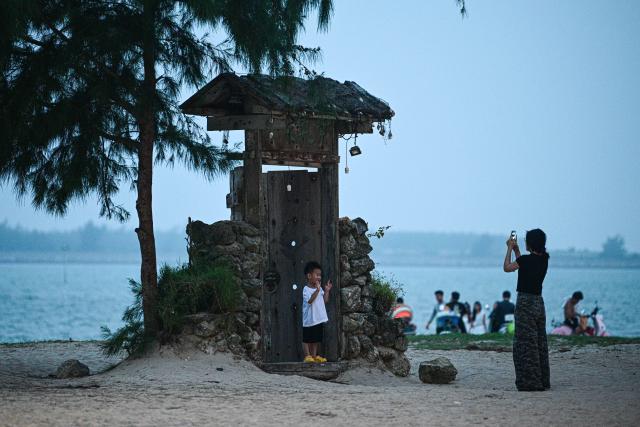 (260725) -- QIONGHAI, July 25, 2026 (Xinhua) -- People enjoy leisure time at Paigang Village of Tanmen Town in Qionghai City, south China's Hainan Province, July 21, 2026. Building on the unique identities of Boao Town, home to the Boao Forum for Asia, and Tanmen Town, a historic fishing port with a thousand-year legacy, Qionghai City has been advancing the coordinated construction of picturesque rural villages across the Boao-Tanmen area. Taking advantage of Hainan's round-the-island highway, the city has linked both newly constructed and previously cultivated beautiful and harmonious villages into a cohesive chain to forge a globally influential rural revitalization belt. (Xinhua/Pu Xiaoxu)