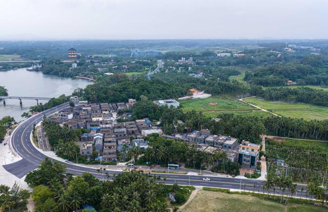 (260725) -- QIONGHAI, July 25, 2026 (Xinhua) -- An aerial drone photo taken on July 21, 2026 shows a view of Hainan's round-the-island highway and Nanqiang Village in Boao Town, Qionghai City, south China's Hainan Province. Building on the unique identities of Boao Town, home to the Boao Forum for Asia, and Tanmen Town, a historic fishing port with a thousand-year legacy, Qionghai City has been advancing the coordinated construction of picturesque rural villages across the Boao-Tanmen area. Taking advantage of Hainan's round-the-island highway, the city has linked both newly constructed and previously cultivated beautiful and harmonious villages into a cohesive chain to forge a globally influential rural revitalization belt. (Xinhua/Pu Xiaoxu)