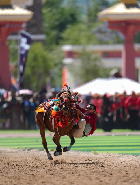 (260725) -- YUSHU, July 25, 2026 (Xinhua) -- A rider shows off equestrian stunts during the opening ceremony of the 44th Yushu horse racing festival in Yushu Tibetan Autonomous Prefecture, northwest China's Qinghai Province, July 25, 2026. The festival kicked off here on Saturday, and will last until August. (Xinhua/Du Xiaowei)