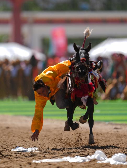 (260725) -- YUSHU, July 25, 2026 (Xinhua) -- A rider shows off equestrian stunts during the opening ceremony of the 44th Yushu horse racing festival in Yushu Tibetan Autonomous Prefecture, northwest China's Qinghai Province, July 25, 2026. The festival kicked off here on Saturday, and will last until August. (Xinhua/Du Xiaowei)