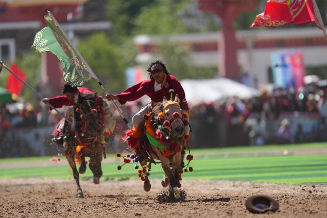 (260725) -- YUSHU, July 25, 2026 (Xinhua) -- Riders show off equestrian stunts during the opening ceremony of the 44th Yushu horse racing festival in Yushu Tibetan Autonomous Prefecture, northwest China's Qinghai Province, July 25, 2026. The festival kicked off here on Saturday, and will last until August. (Xinhua/Du Xiaowei)