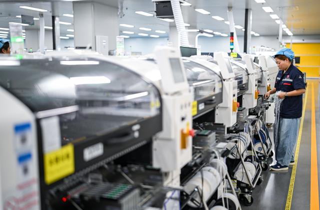 (260725) -- NANTONG, July 25, 2026 (Xinhua) -- A staff member works in an energy storage production workshop at the Sigenergy Nantong Smart Energy Center in Nantong, east China's Jiangsu Province, July 24, 2026. Unlike traditional factories, Sigenergy has achieved a leap from "single-point automation" to "full-process collaborative intelligence." Every key piece of equipment here is connected to the industrial internet, realizing the practical integration of "AI plus energy."
   Sigenergy is one of the Chinese new energy enterprises who are adhering to technological innovation and actively reshaping the new pattern of intelligent manufacturing. (Xinhua/Chen Yehua)