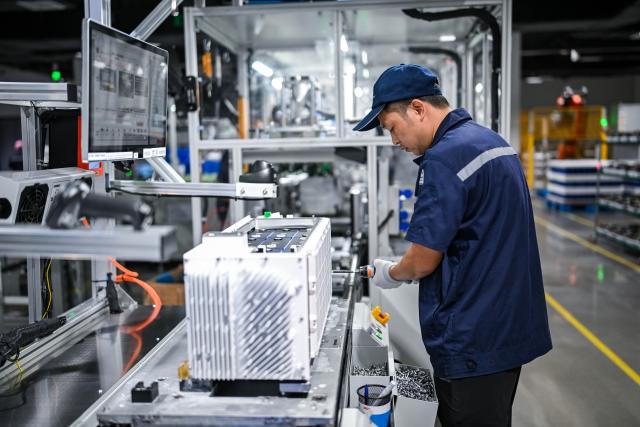 (260725) -- NANTONG, July 25, 2026 (Xinhua) -- A staff member works in an energy storage production workshop at the Sigenergy Nantong Smart Energy Center in Nantong, east China's Jiangsu Province, July 24, 2026. Unlike traditional factories, Sigenergy has achieved a leap from "single-point automation" to "full-process collaborative intelligence." Every key piece of equipment here is connected to the industrial internet, realizing the practical integration of "AI plus energy."
   Sigenergy is one of the Chinese new energy enterprises who are adhering to technological innovation and actively reshaping the new pattern of intelligent manufacturing. (Xinhua/Chen Yehua)