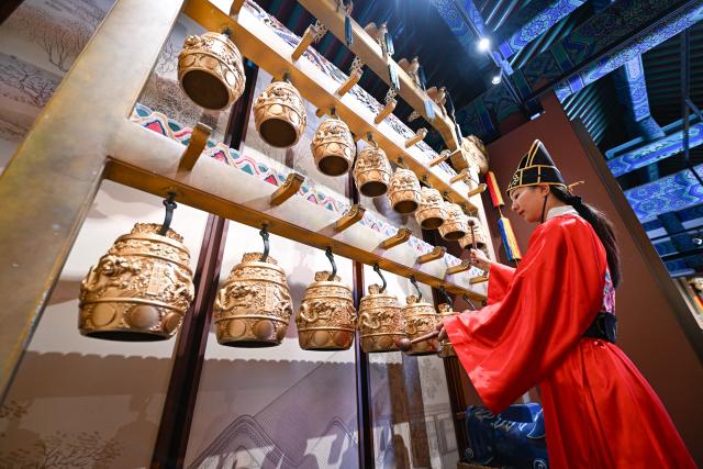 (260725) -- BEIJING, July 25, 2026 (Xinhua) -- A staff member plays bianzhong, or chime bells, at the Divine Music Administration inside the Temple of Heaven Park in Beijing, capital of China, July 24, 2026. The renovated Divine Music Administration has opened to the public since February in 2026, it also serves as a main exhibition area of the museum of the Temple of Heaven since June this year. Marking the second anniversary of the successful inscription of the Beijing Central Axis on the UNESCO World Heritage List, heritage sites along the Beijing Central Axis, such as the Palace Museum, Zhengyangmen Gate, and Altar of the God of Agriculture, also referred to as the Xiannongtan Temple, will either open to the public free of charge or launch new exhibitions on July 27.
  Over the past two years, efforts to conserve, inherit and make good use of the Beijing Central Axis have advanced steadily, achieving new outcomes in areas including related legal system, UNESCO World Heritage signage, landscape improvement, creative utilization, collaborative protection and international communication. (Xinhua/Chen Zhonghao)