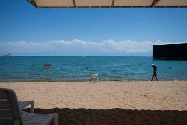 (260725) -- ISSYK-KUL LAKE, July 25, 2026 (Xinhua) -- A woman walks on the shore of Issyk-Kul Lake in Kyrgyzstan, on July 24, 2026. Issyk-Kul Lake, located in the northeastern part of Kyrgyzstan, covers an area of more than 6,000 square kilometers and ranks as the world's second-largest alpine lake. (Xinhua/Li Renzi)