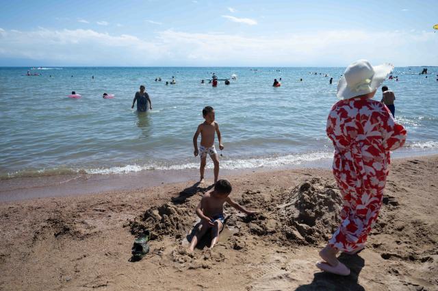 (260725) -- ISSYK-KUL LAKE, July 25, 2026 (Xinhua) -- Children play on the shore of Issyk-Kul Lake in Kyrgyzstan, on July 23, 2026. Issyk-Kul Lake, located in the northeastern part of Kyrgyzstan, covers an area of more than 6,000 square kilometers and ranks as the world's second-largest alpine lake. (Xinhua/Li Renzi)