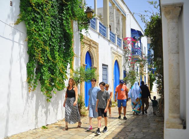 (260725) -- TUNIS, July 25, 2026 (Xinhua) -- Visitors walk on an alley in the blue and white village of Sidi Bou Said, north of Tunisia, July 25, 2026. Tunisia's iconic village of Sidi Bou Said has been inscribed on the UNESCO World Heritage List, the country's Ministry of Cultural Affairs said on Saturday. (Photo by Adel Ezzine/Xinhua)