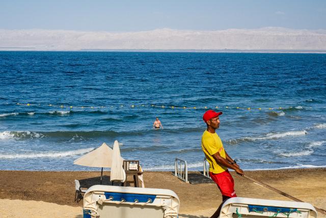 (260726) -- AMMAN, July 26, 2026 (Xinhua) -- A man relaxes in the Dead Sea in Jordan, on July 25, 2026. The Dead Sea has been experiencing a long-term decline in its water level due to reduced inflow from the Jordan River, the region's naturally high evaporation rates, and industrial mineral extraction. Available data show that as of July 2026, the Dead Sea's surface was approximately 440 meters below sea level, and its water level has been declining by an average of more than one meter annually. (Xinhua/Xin Mengchen)