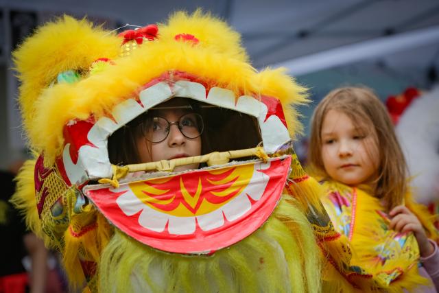 (260726) -- VANCOUVER, July 26, 2026 (Xinhua) -- Children try a lion dance performance during the Chinatown Festival in Vancouver, British Columbia, Canada, July 25, 2026. The two-day cultural festival kicked off here on Saturday, celebrating the heritage of Vancouver's historic Chinatown with traditional cultural performances, local food vendors and family-friendly activities. (Photo by Liang Sen/Xinhua)