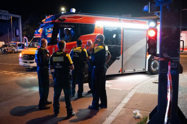 (260726) -- BERLIN, July 26, 2026 (Xinhua) -- Police officers work near the site where a car drove into a crowd in Berlin, Germany, July 26, 2026. One person was killed and 16 others were injured, including several with life-threatening injuries, after a car drove into a crowd at a large Pride celebration in central Berlin on Saturday evening, a police spokesperson said. (Xinhua/Zhang Haofu)