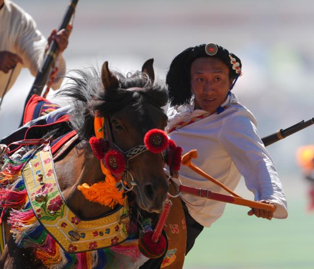 (260726) -- BEIJING, July 26, 2026 (Xinhua) -- A rider shows off equestrian stunts during the opening ceremony of the 44th Yushu horse racing festival in Yushu Tibetan Autonomous Prefecture, northwest China's Qinghai Province, July 25, 2026. The festival kicked off here on Saturday, and will last until August. (Xinhua/Du Xiaowei)
