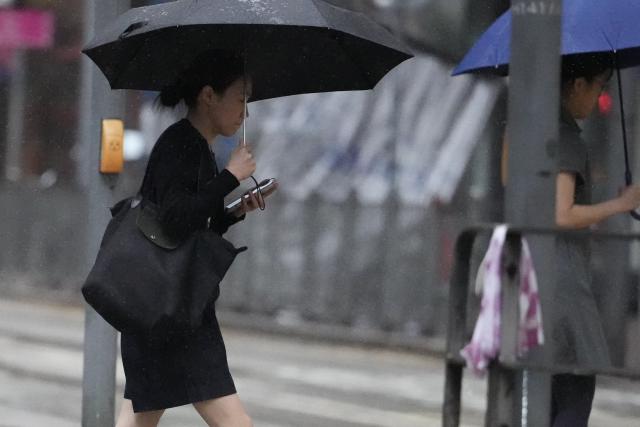 (260726) -- HONG KONG, July 26, 2026 (Xinhua) -- People walk amid rain in Hong Kong, south China, July 26, 2026. The Hong Kong Observatory issued the No. 8 Northwest Gale or Storm Signal on Saturday night under the effect of super typhoon Noul.
   The No. 8 signal is the third-highest warning under Hong Kong's weather system, which has five rankings for typhoons. (Photo by Lui Siu Wai/Xinhua)