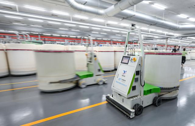 (260726) -- YANCHENG, July 26, 2026 (Xinhua) -- Robots carry barrels at a factory in Jiangsu Yueda Textile Group Co., Ltd. in Yancheng City, east China's Jiangsu Province, July 25, 2026. Jiangsu Yueda Textile Group Co., Ltd. has been recognized as a "Global Lighthouse Factory" due to its recent advancements in intelligent, digital, and green transformations, which have enhanced production efficiency and product quality.
  In recent years, Yancheng has focused on intelligent manufacturing and industrial upgrading in its industrial enterprises. By promoting technological innovation and optimizing the industrial chain, the city has forged a new path of high-quality development. (Xinhua/Chen Yehua)