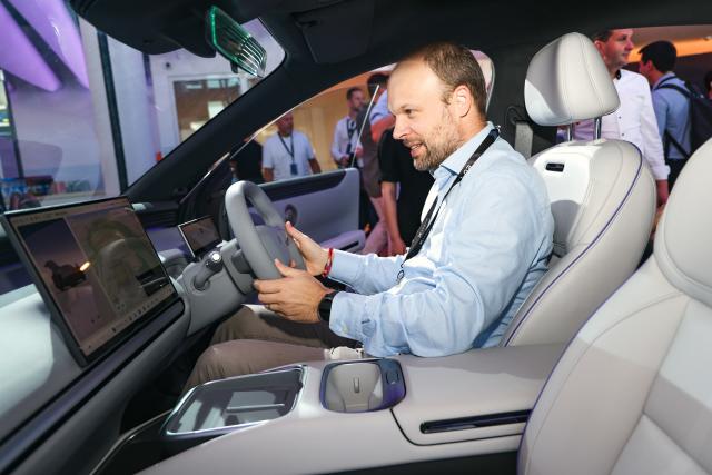(260726) -- GUANGZHOU, July 26, 2026 (Xinhua) -- A man tries out Xpeng's newly-launched MONA L03 car at an unveiling event in Munich, Germany, July 16, 2026. (Xinhua)