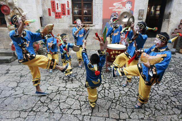 (260726) -- WENLING, July 26, 2026 (Xinhua) -- Actors perform Dazou drum, a national intangible cultural heritage, for tourists in Liruo Village of Shitang Town, Wenling City, east China's Zhejiang Province, June 28, 2026. Liruo is a village located in the southwestern part of Shitang Town, Wenling City. For generations, local residents have relied on the sea for their livelihood. The village is known for its distinctive stone constructions, which were built to withstand typhoons and other severe weather.
   Today, the ancient fishing village is boosting its cultural and tourism industries. Many traditional stone houses have been transformed into cafes and homestays, while fishing nets are crafted into handbags, serving as souvenirs for tourists together with other cultural and creative products. (Photo by Mo Chaoren/Xinhua)