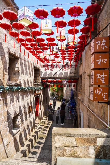 (260726) -- WENLING, July 26, 2026 (Xinhua) -- Tourists visit traditional stone houses in Liruo Village of Shitang Town, Wenling City, east China's Zhejiang Province, May 2, 2026. Liruo is a village located in the southwestern part of Shitang Town, Wenling City. For generations, local residents have relied on the sea for their livelihood. The village is known for its distinctive stone constructions, which were built to withstand typhoons and other severe weather.
   Today, the ancient fishing village is boosting its cultural and tourism industries. Many traditional stone houses have been transformed into cafes and homestays, while fishing nets are crafted into handbags, serving as souvenirs for tourists together with other cultural and creative products. (Xinhua/Jiang Han)