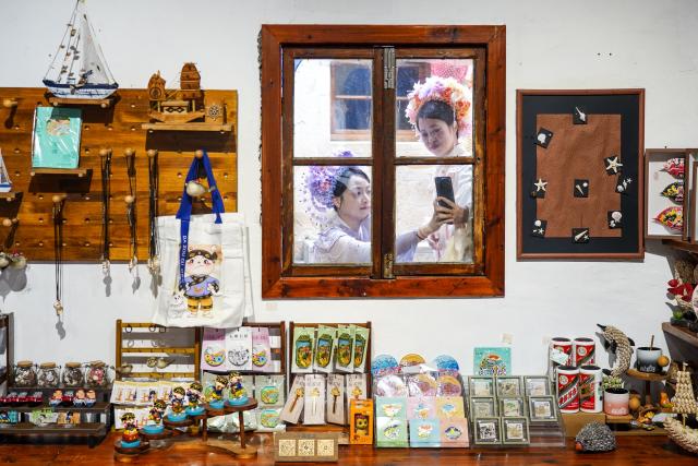 (260726) -- WENLING, July 26, 2026 (Xinhua) -- Tourists take photos in Liruo Village of Shitang Town, Wenling City, east China's Zhejiang Province, May 2, 2026. Liruo is a village located in the southwestern part of Shitang Town, Wenling City. For generations, local residents have relied on the sea for their livelihood. The village is known for its distinctive stone constructions, which were built to withstand typhoons and other severe weather.
   Today, the ancient fishing village is boosting its cultural and tourism industries. Many traditional stone houses have been transformed into cafes and homestays, while fishing nets are crafted into handbags, serving as souvenirs for tourists together with other cultural and creative products. (Xinhua/Jiang Han)