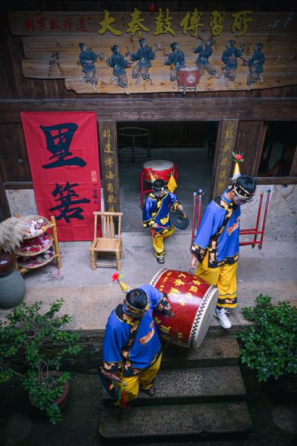 (260726) -- WENLING, July 26, 2026 (Xinhua) -- Actors prepare to perform Dazou drum, a national intangible cultural heritage, for tourists in Liruo Village of Shitang Town, Wenling City, east China's Zhejiang Province, June 28, 2026. Liruo is a village located in the southwestern part of Shitang Town, Wenling City. For generations, local residents have relied on the sea for their livelihood. The village is known for its distinctive stone constructions, which were built to withstand typhoons and other severe weather.
   Today, the ancient fishing village is boosting its cultural and tourism industries. Many traditional stone houses have been transformed into cafes and homestays, while fishing nets are crafted into handbags, serving as souvenirs for tourists together with other cultural and creative products. (Xinhua/Jiang Han)
